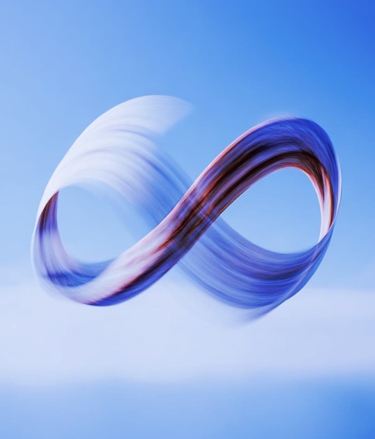 Abstract swirling infinity symbol against a clear blue sky, creating a sense of motion and fluidity.