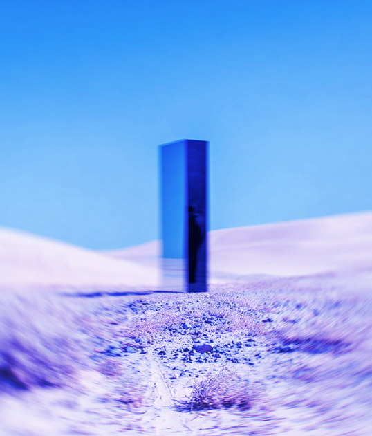 Two airport ground crew members in orange uniforms walk on the tarmac at sunset, with an airplane in the background.