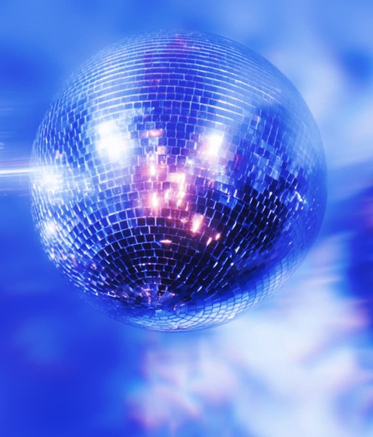 A shiny disco ball reflecting colorful lights against a blurred blue background.