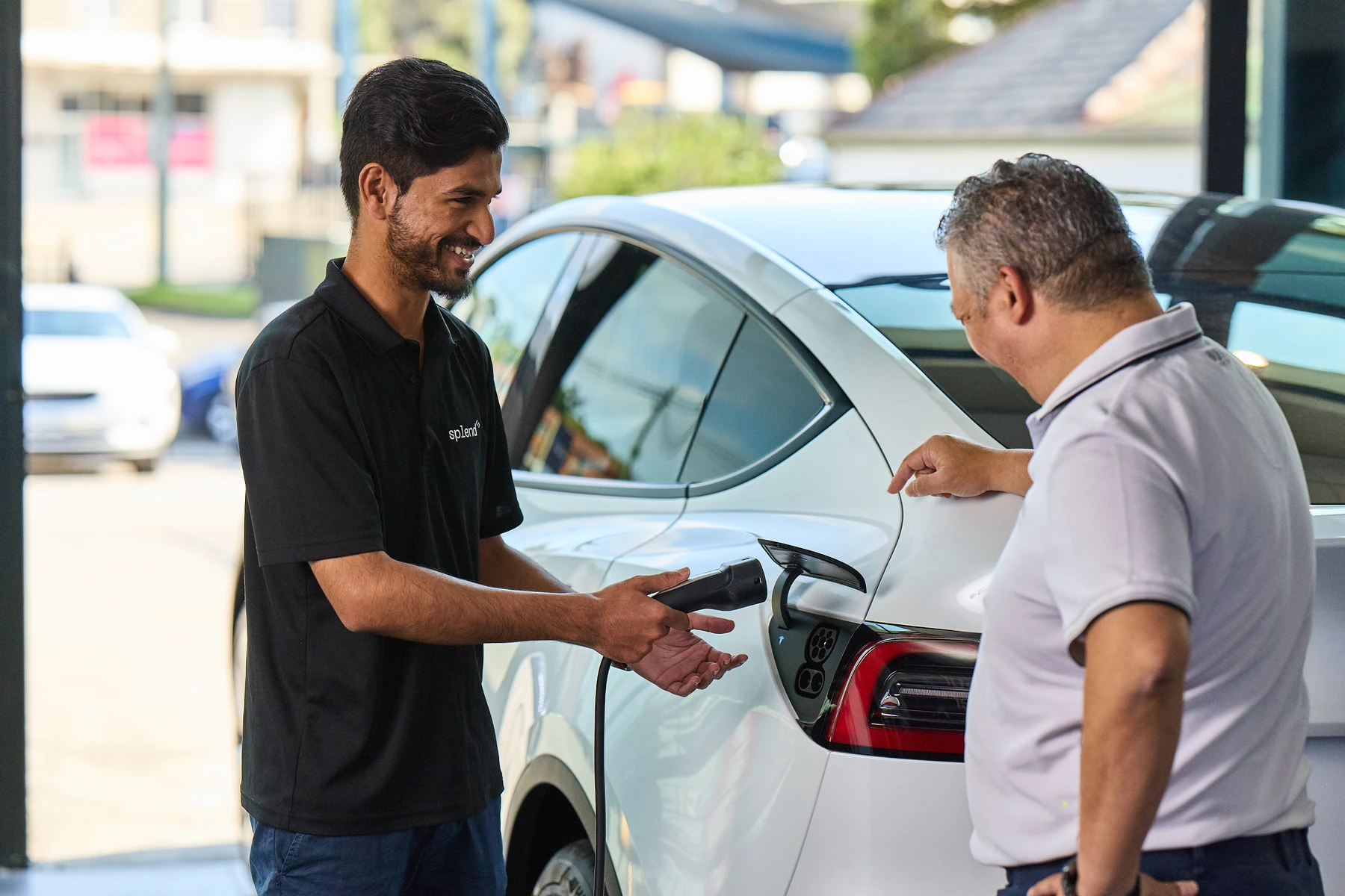 Splend employee showing how to charge a Tesla Model Y