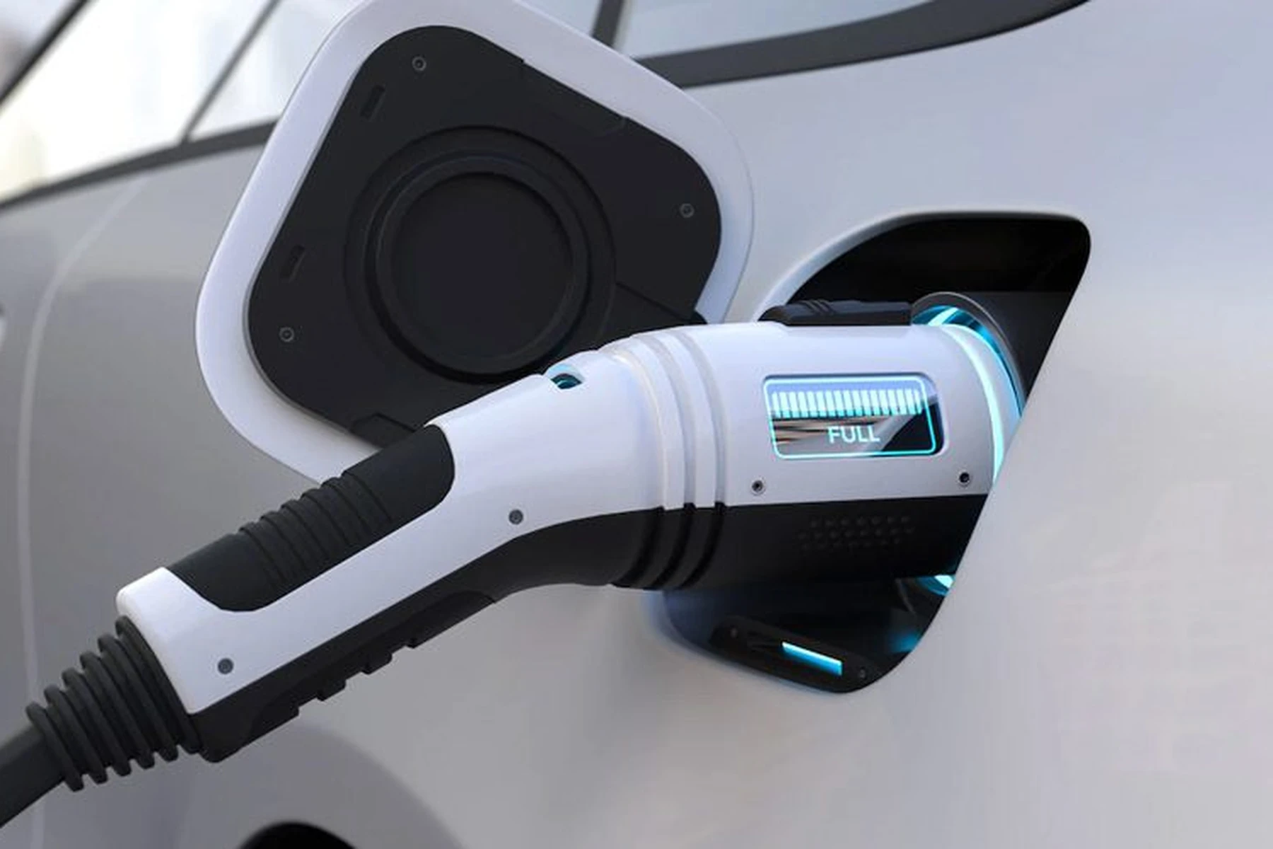 Close-up of an electric car charging with a plugged-in EV charger showing a full battery indicator.