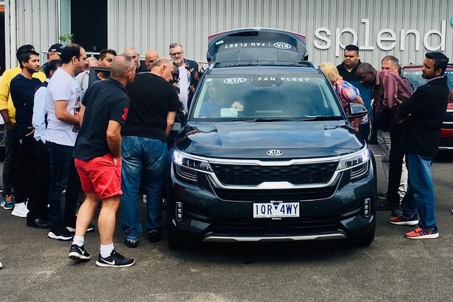 A group of people surrounding a Kia Vehicle in front of the Melbourne Splend hub
