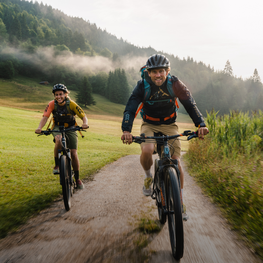 zwei menschen mountainbiken durch wald
