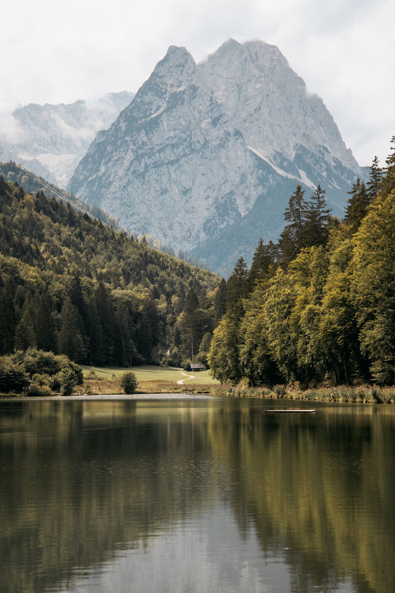 Ein Bergsee in Bayern, umgeben von Wald, im Mittelpunkt ein großer Berg.