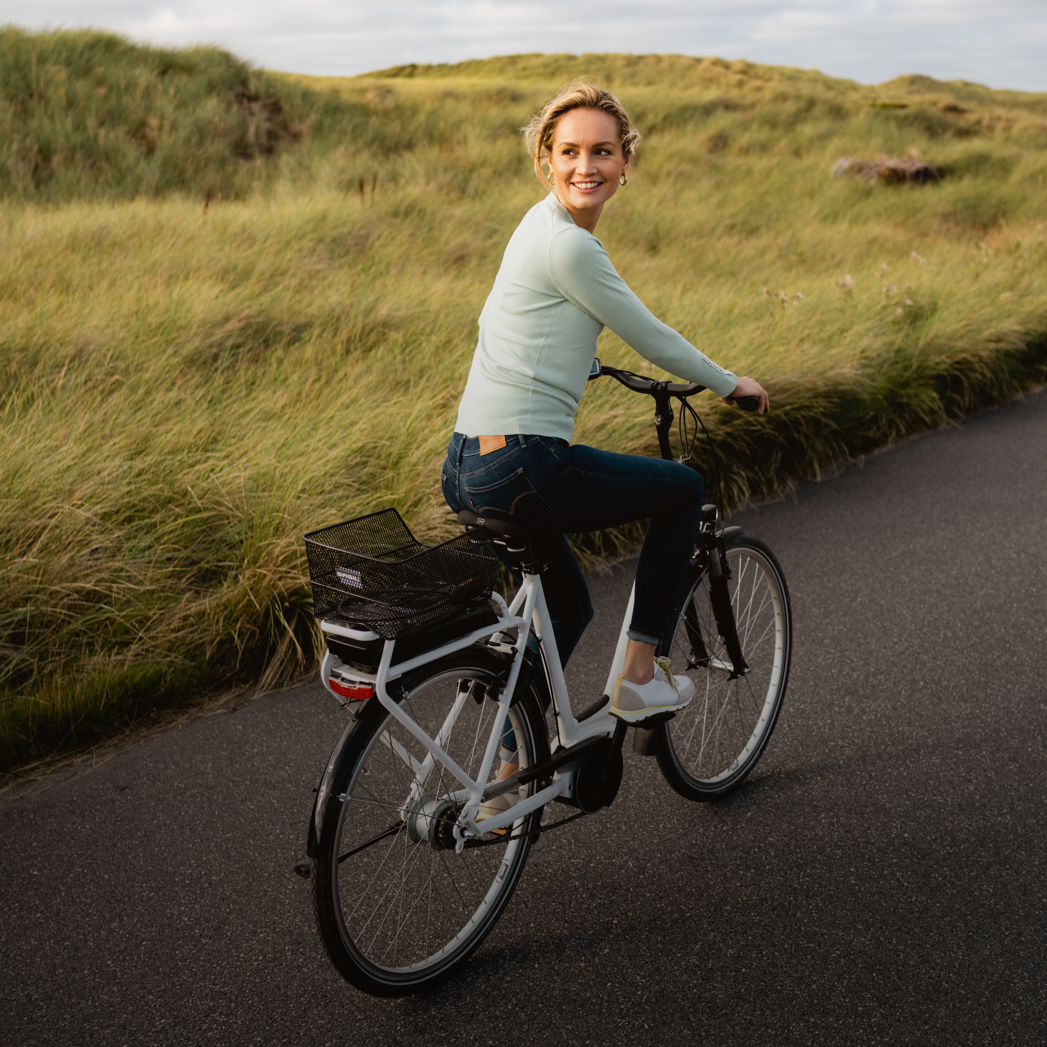 Frau fährt in der Düne mit dem Fahrrad