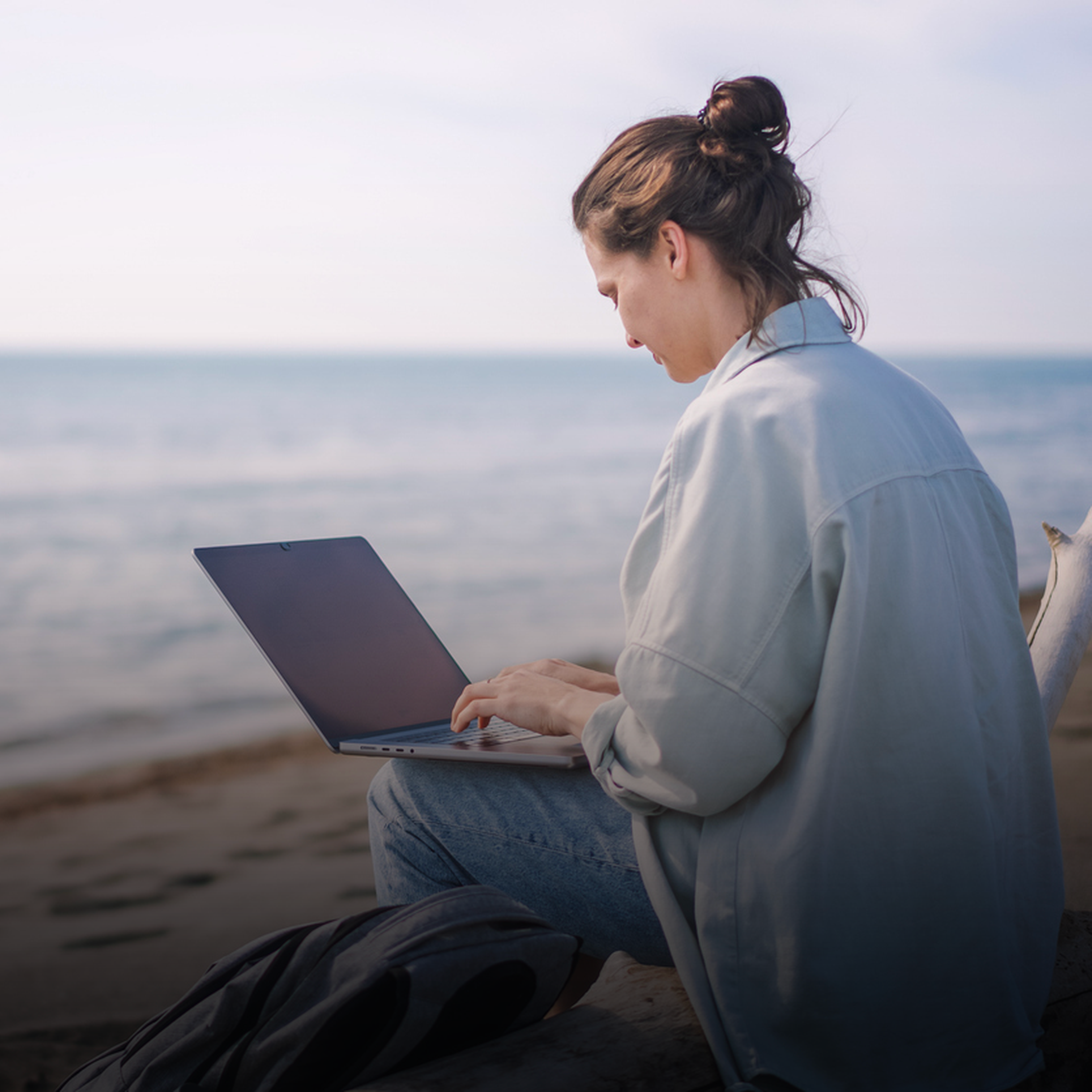 frau mit laptop am strand