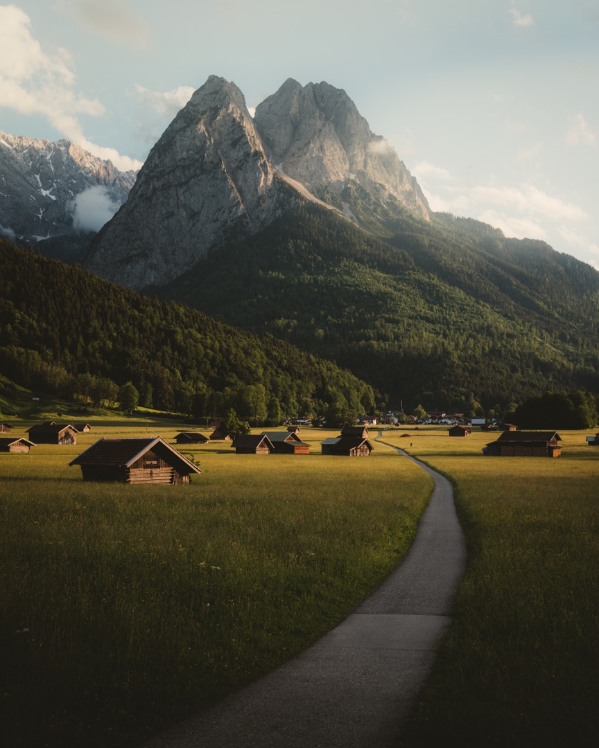 Bergkulisse im Sommer mit Wiese und Almhütten.
