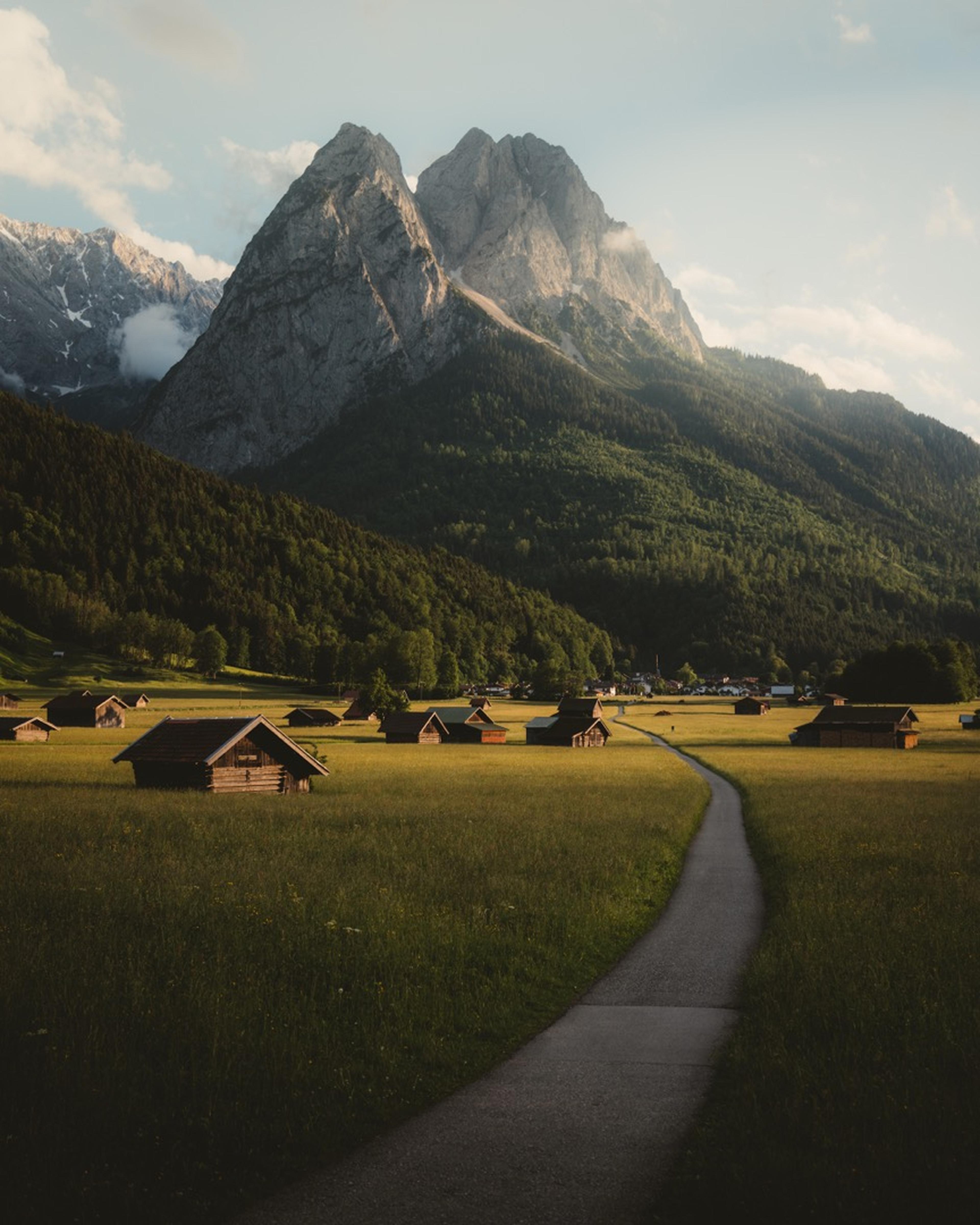 Bergkulisse im Sommer mit Wiese und Almhütten.