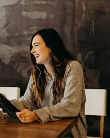 One woman sitting at a desk smiling