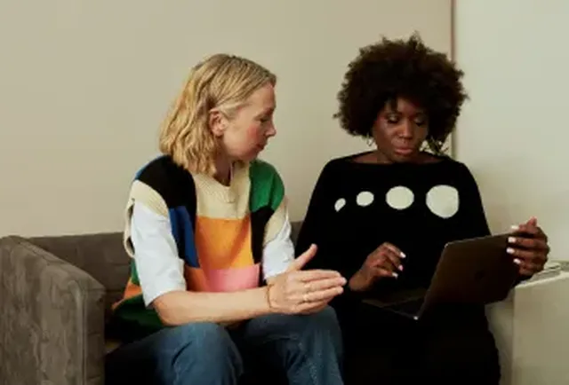 Two women on a couch in discussion