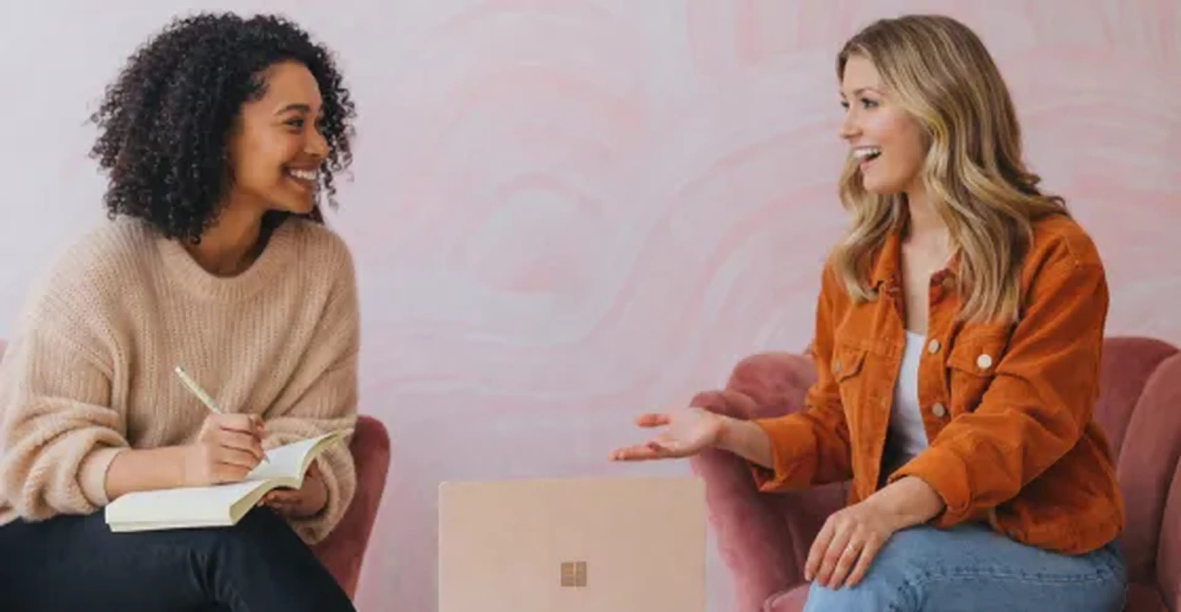 Two women sat smiling in discussion