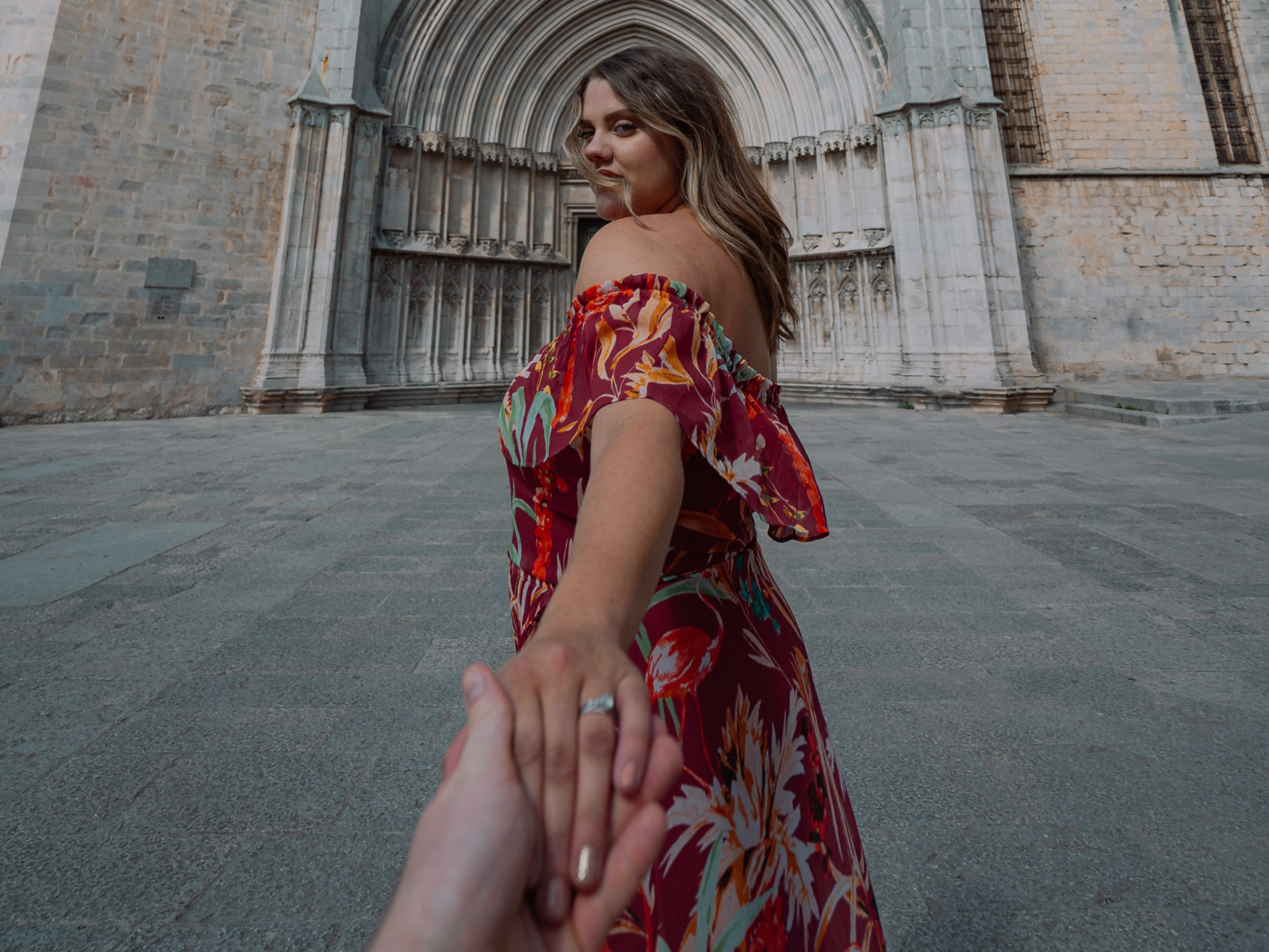 A travel picture of a couple where a woman inviting man to see a gorgeous cathedral