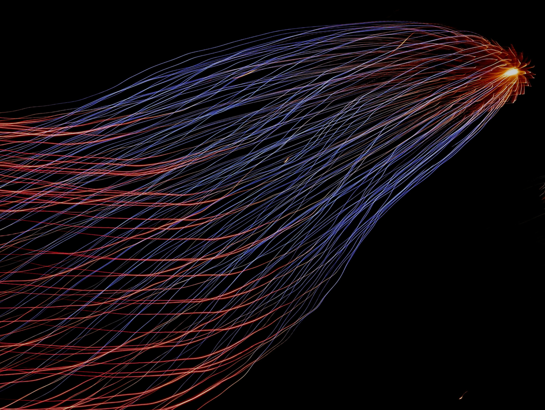 An abstract stream formed of colourful lines moving from chaotic direction towards one bright spark