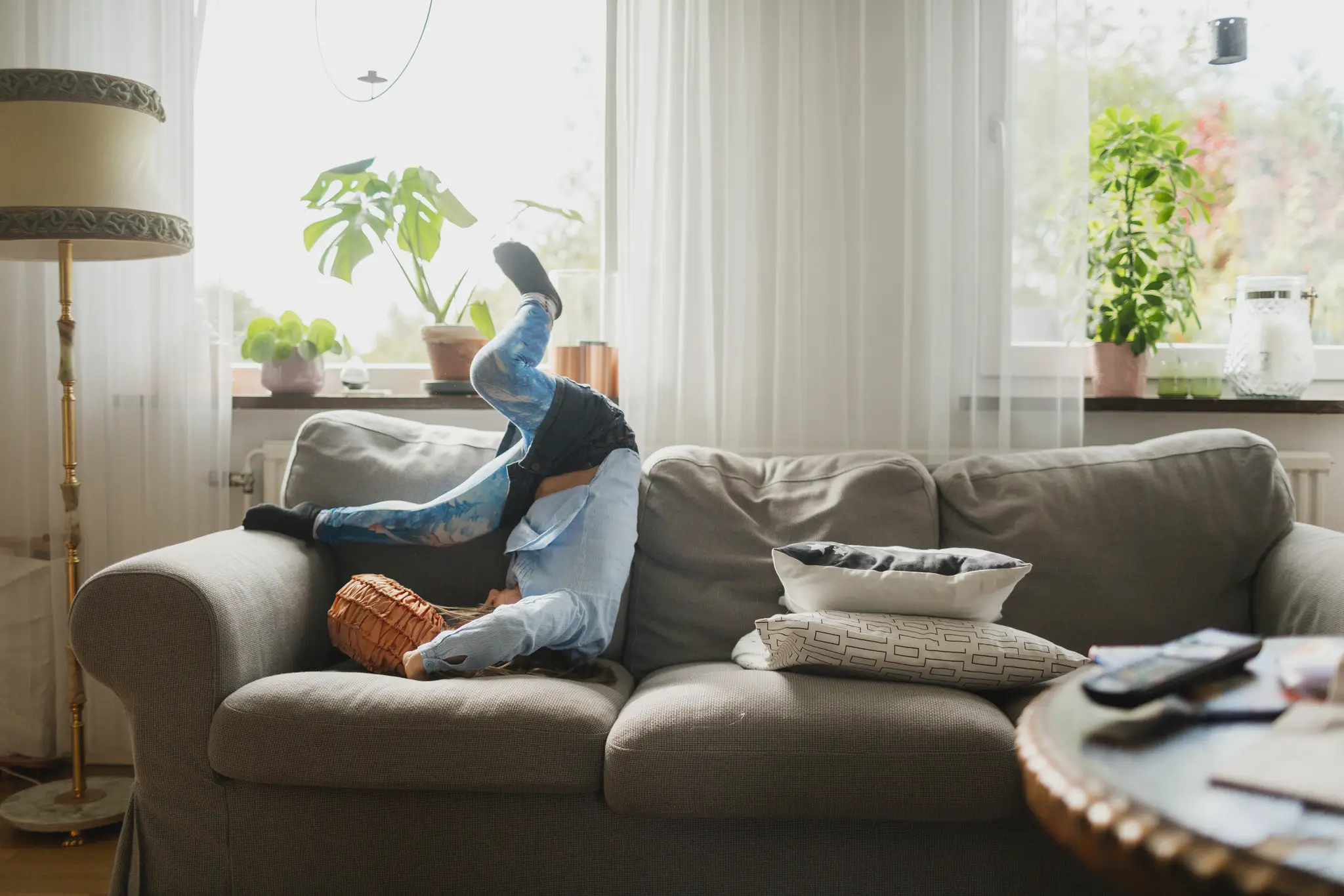 En flicka hoppar i en soffa i ett vardagsrum