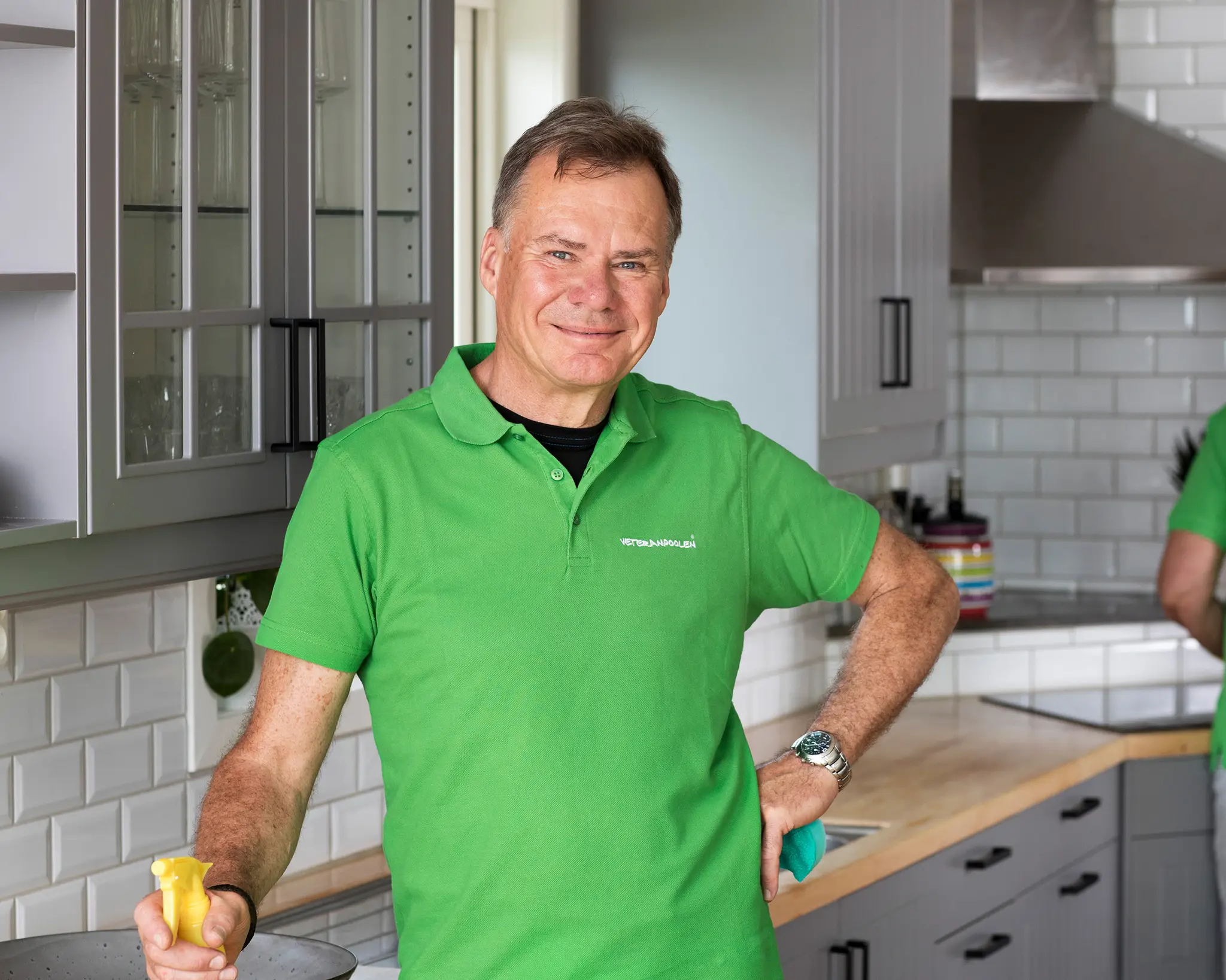 Manlig städveteran står i ett kök