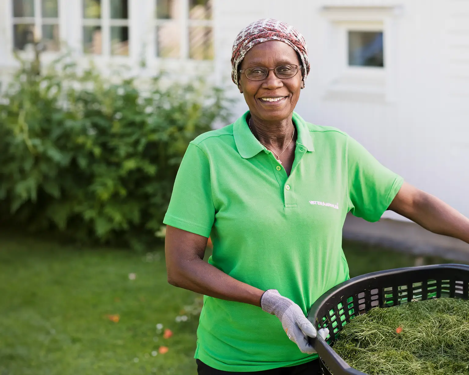 Kvinnlig jobbonär håller i en korg med gräsklipp