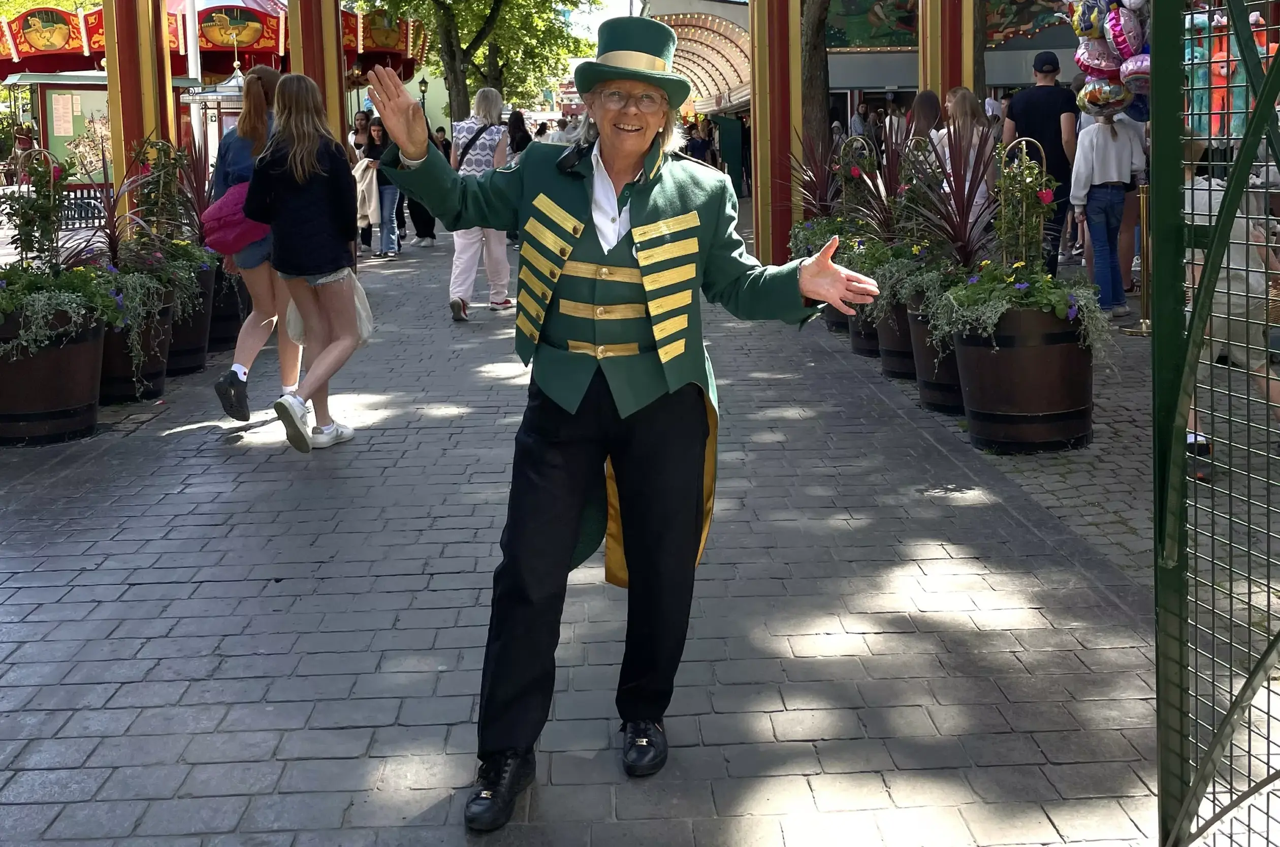 En kvinna klädd i grön frack står på Gröna Lund