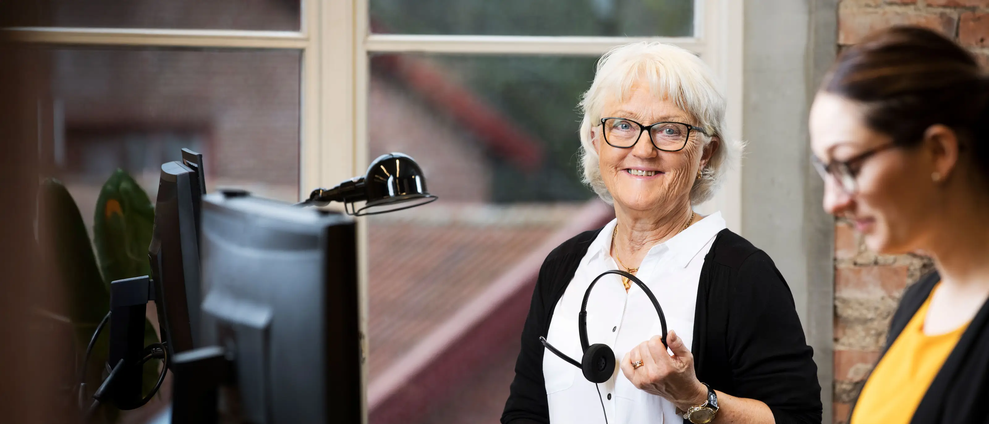 En kvinnlig jobbonär står vid ett skrivbord med dator