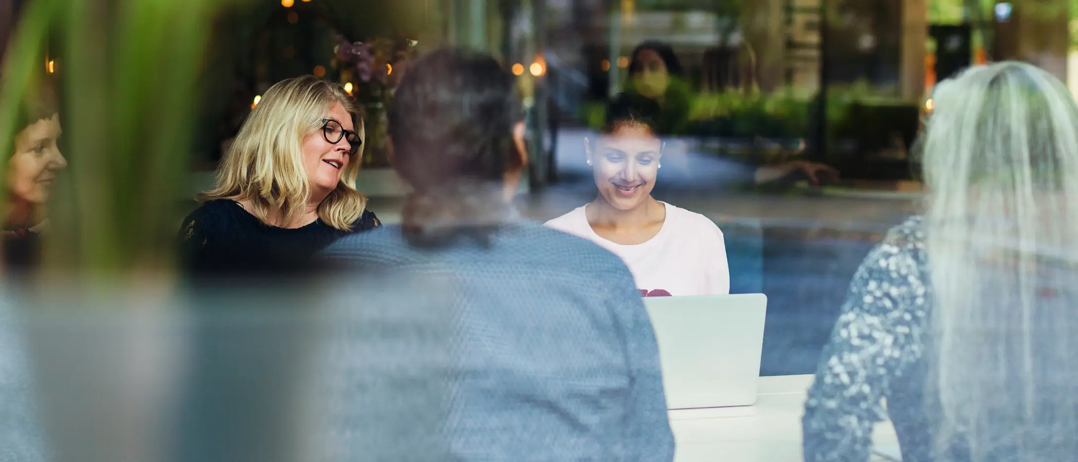 Kollegor sitter och pratar och tittar på en laptop