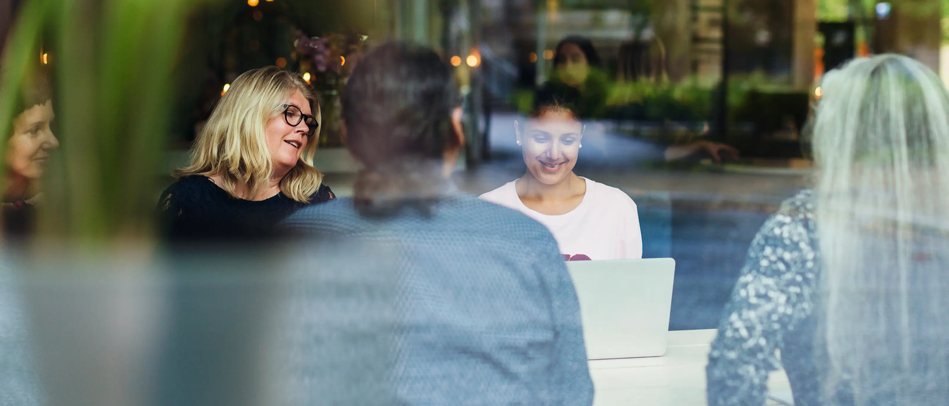 Kollegor sitter och pratar och tittar på en laptop