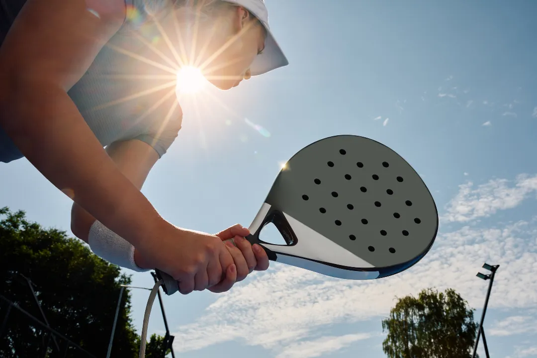 Person mit Kappe bereitet sich auf den Serve vor - Padel Match