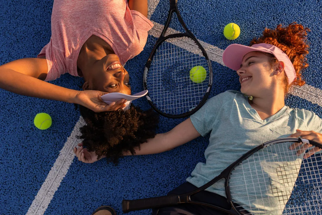 zwei Frauen erschöpft nach dem Spiel auf dem Boden