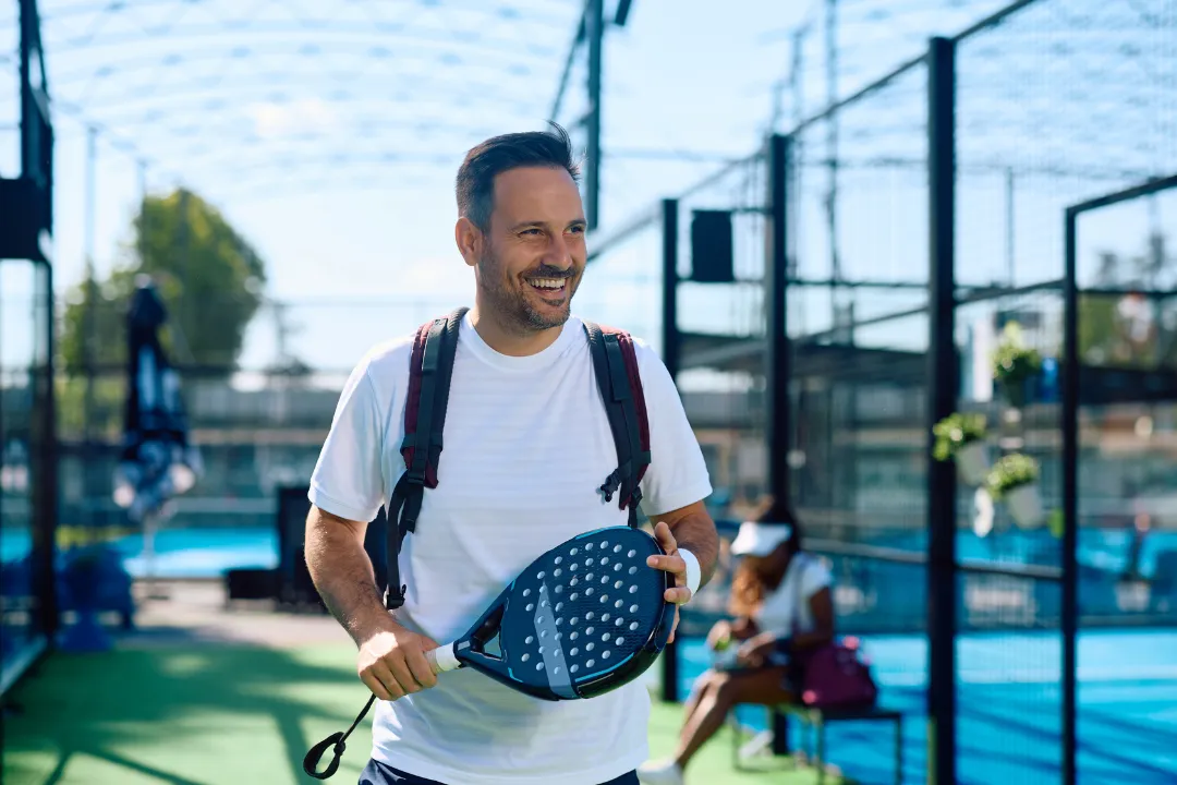 Mann ist glücklich am Padel Court outdoor vor dem Padelspiel
