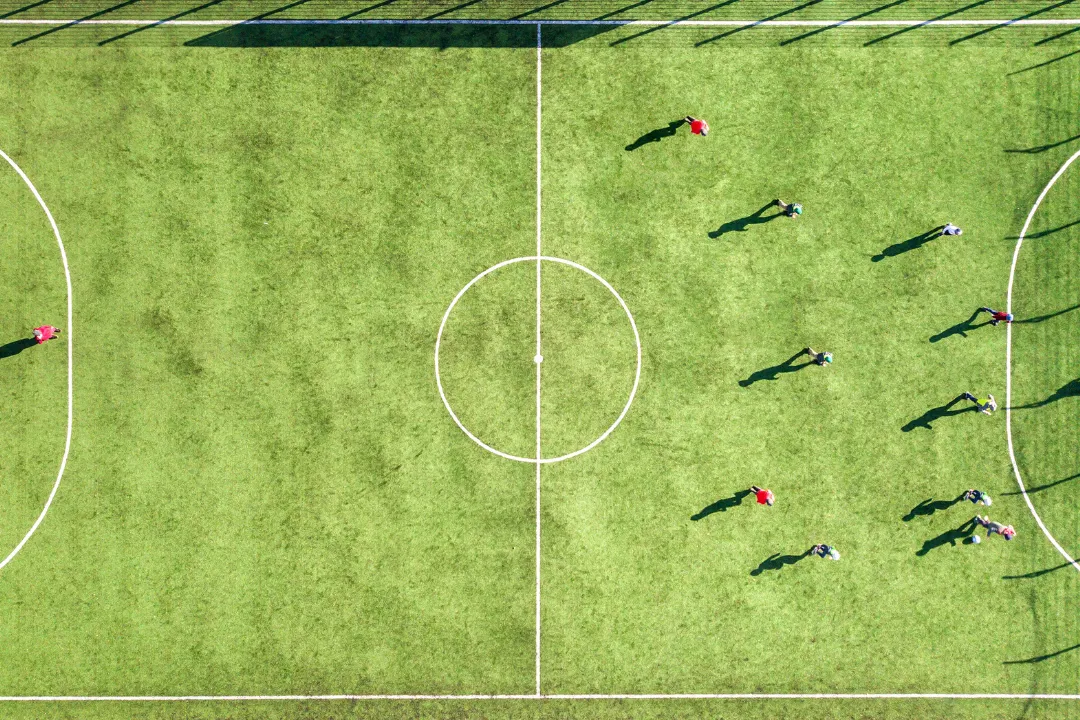 Vogelsicht auf ein Fußballplatz mit Spielern, das managen von der Anlage ganz einfach mit dem Ballsports Eversports Manager