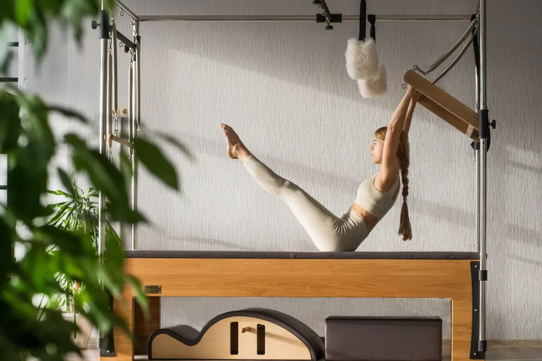 Frau praktiziert am Reformer Pilates indoor, die Buchung über Eversports ging leicht