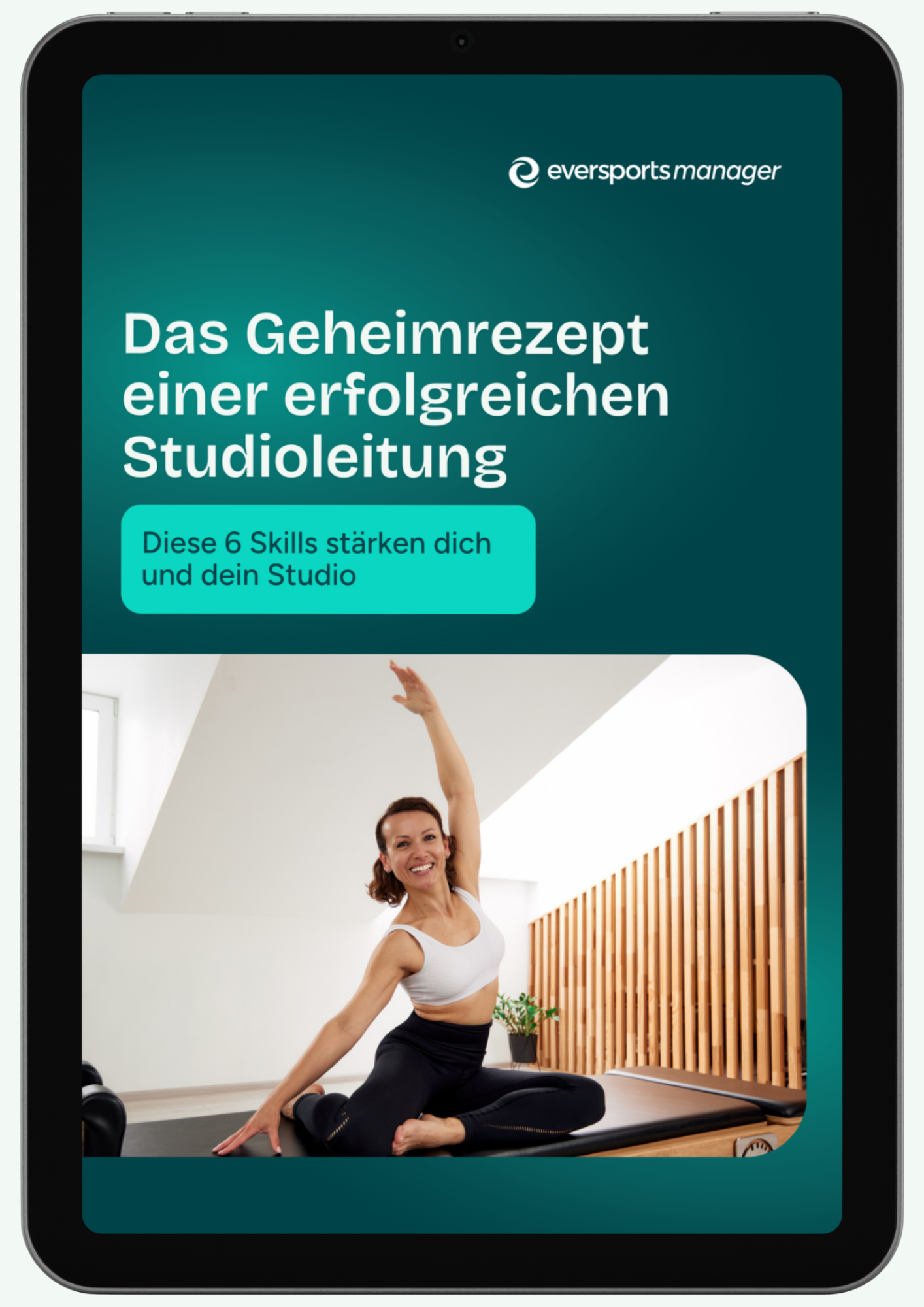 Smiling woman in a fitness studio stretching on a mat.