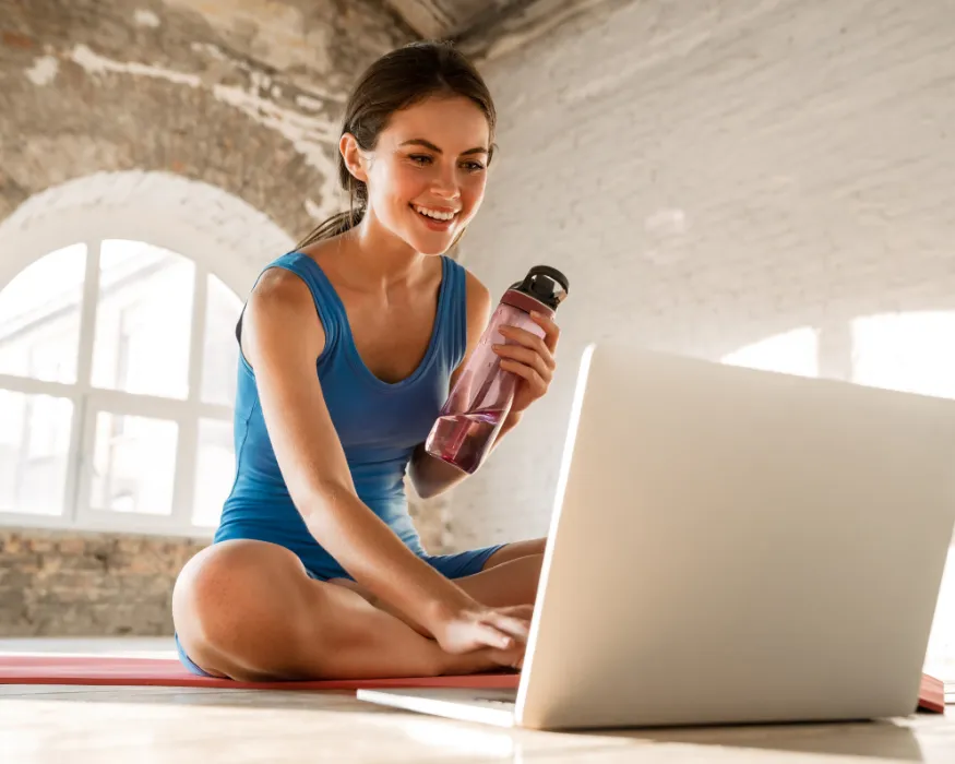 Studiobesitzerin trainiert auf einer Matte mit Eversports Manager am PC