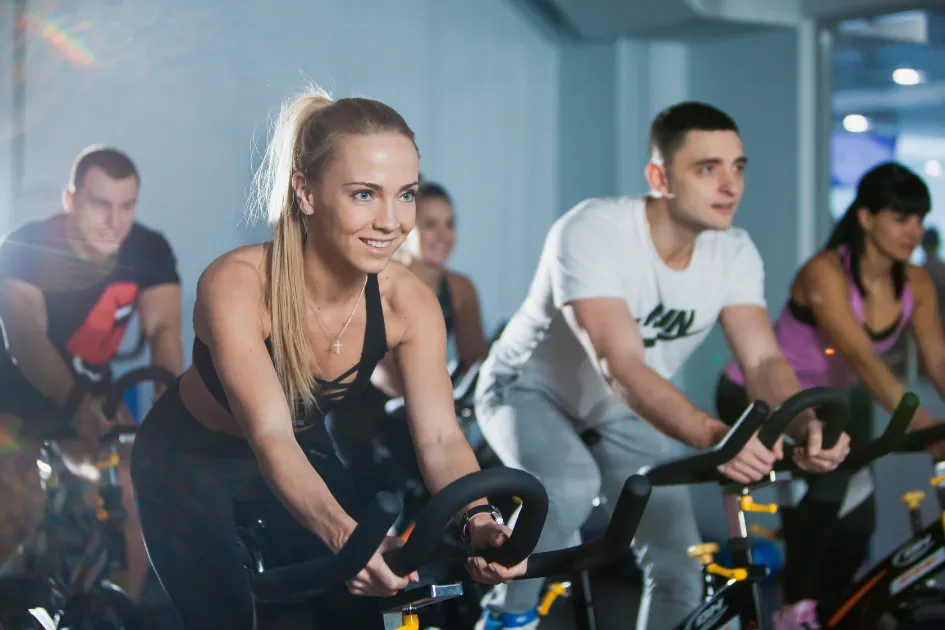 Gruppe von Personen bei Indoor Cycling lächelnd da sie so einfach gebucht haben