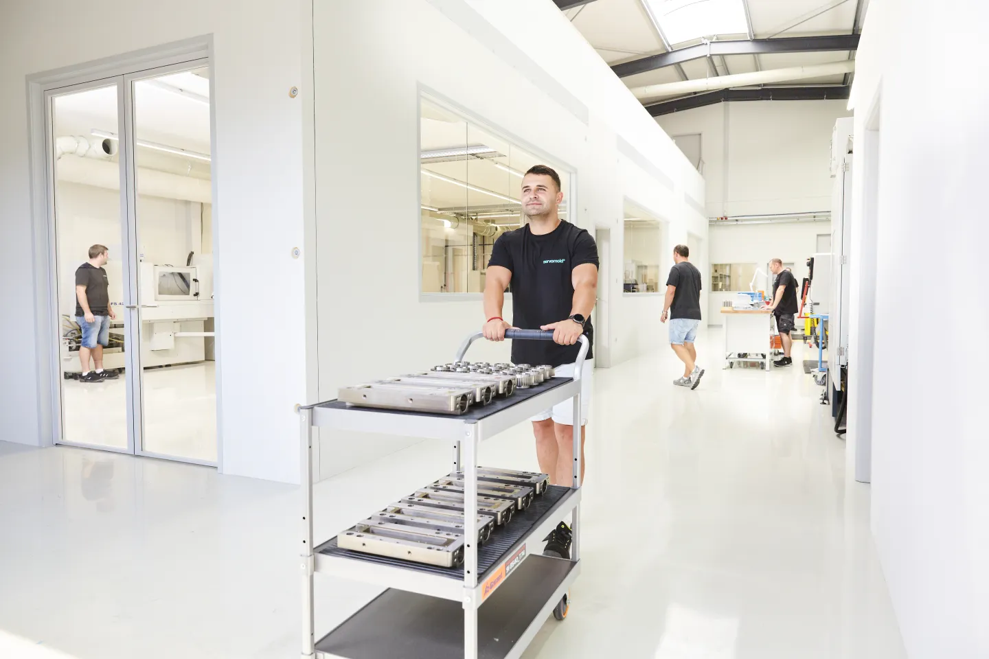 mitarbeiter aus der Logistik bewegt Teile durch die Produktionshalle