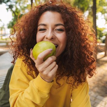 Frau isst Apfel