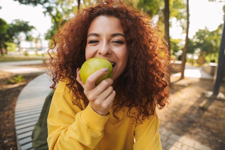 Frau isst Apfel