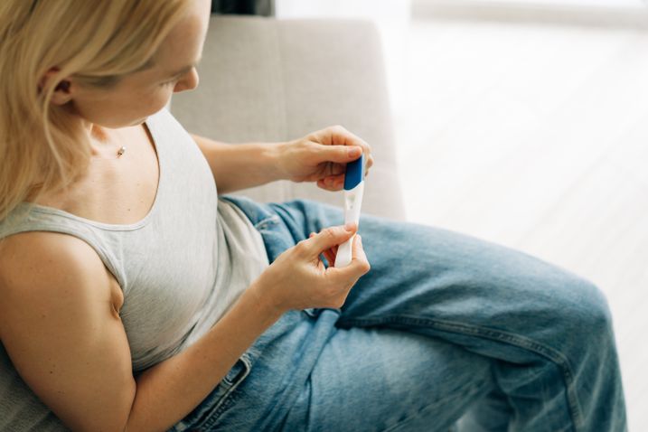 Frau hält Schwangerschaftstest in der Hand