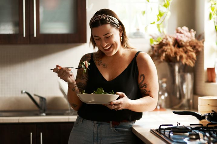 Frau isst Bowl in der Küche