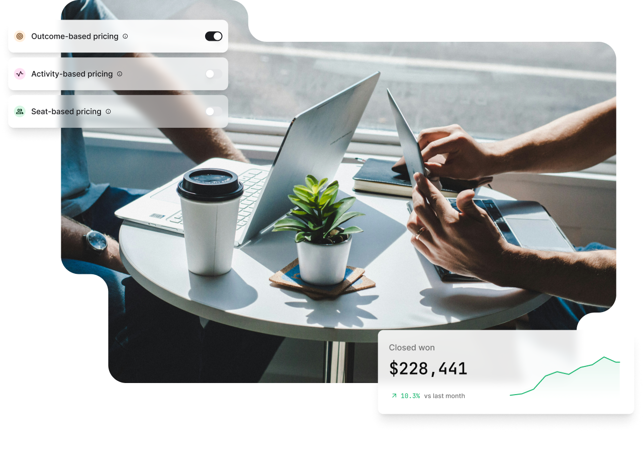 Two people working at a small round table with laptops, a coffee cup, and a small plant. Toggle switches for pricing options are visible.