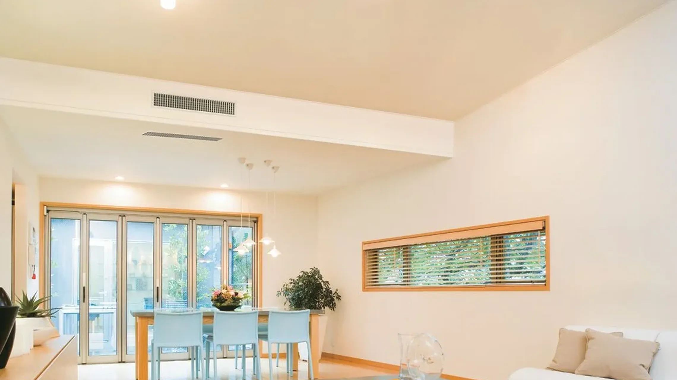 A dining room with air ducts in the ceiling