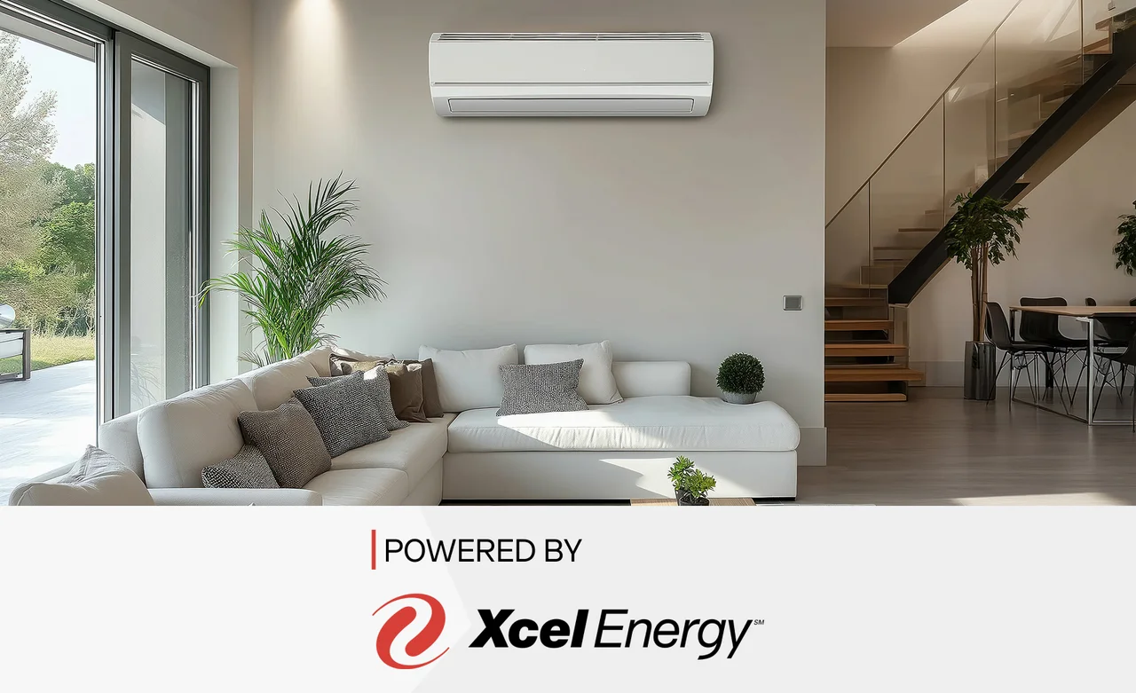 A mini split unit above a couch with the text "powered by Xcel Energy" and the Xcel Energy logo