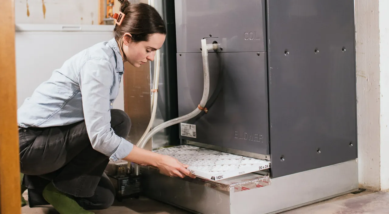 A technician installs a filter in a heat pump