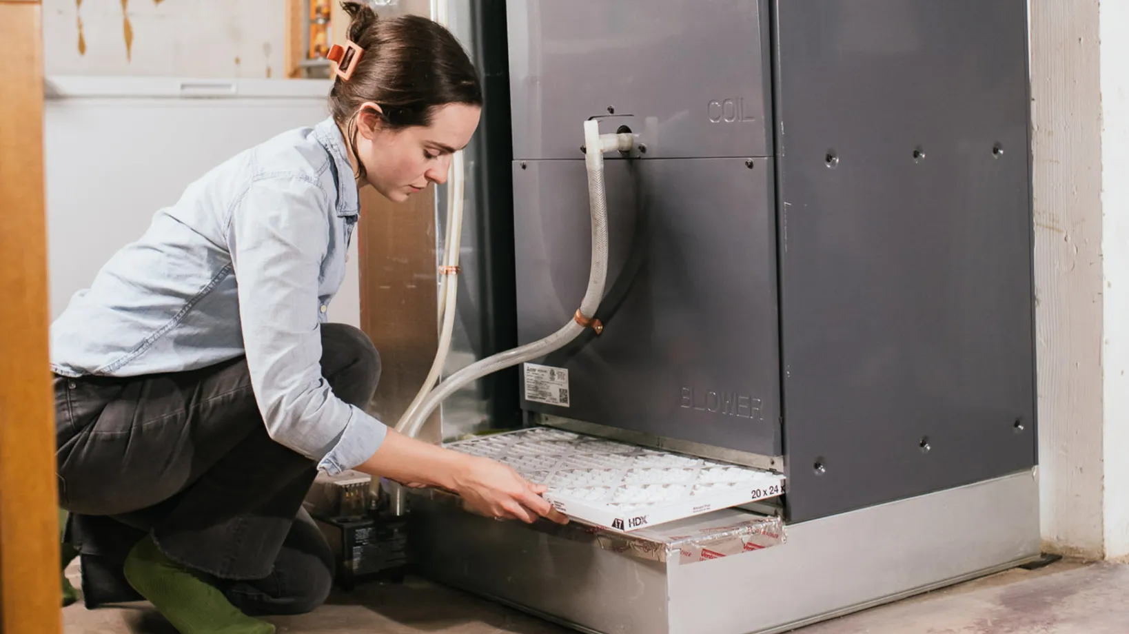 A technician installs a filter in a heat pump