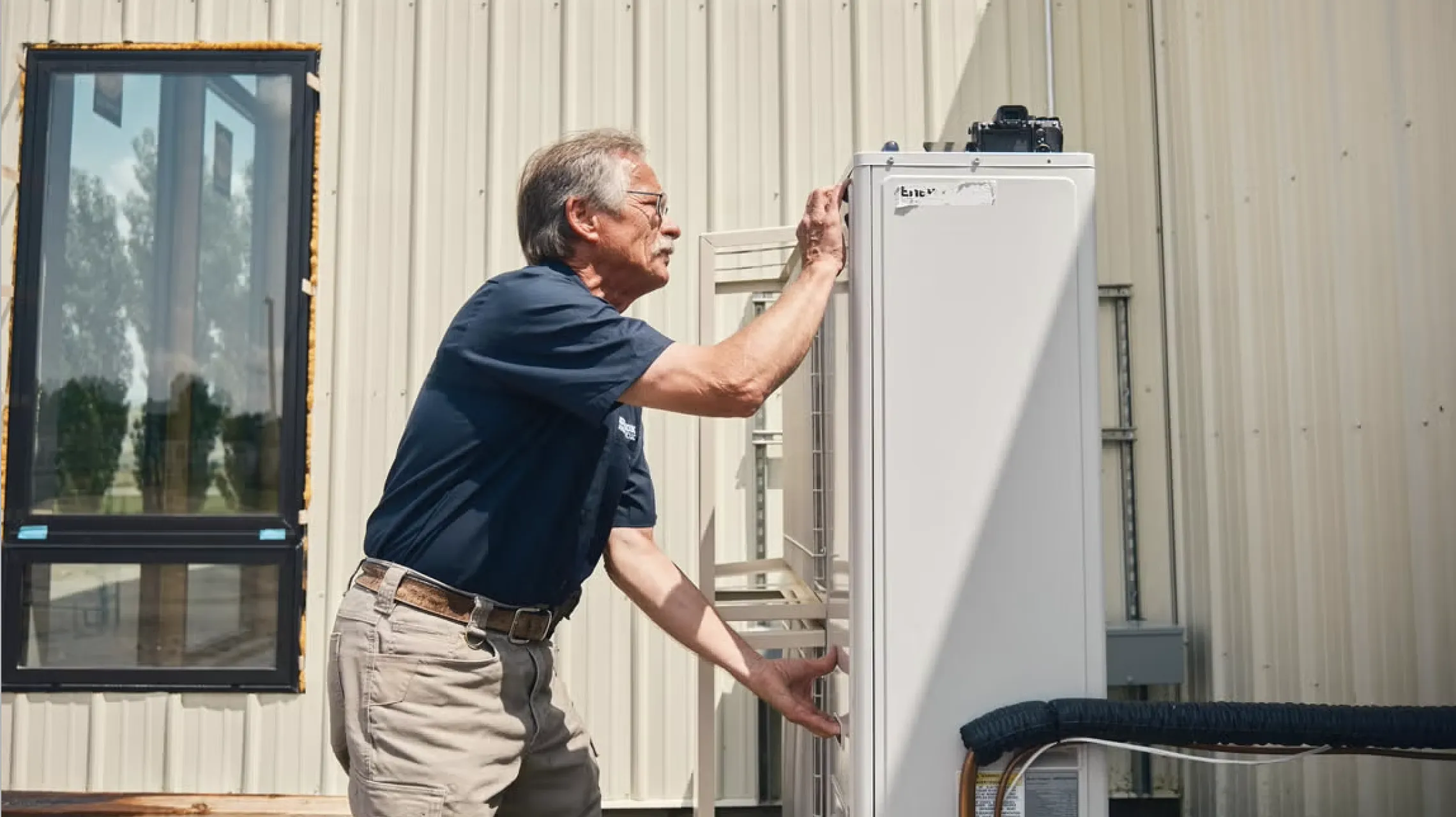Heat pump technician performing a rural installation