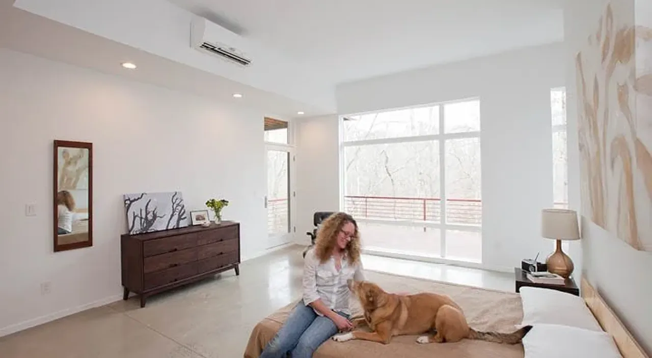 A bedroom with a mini split heat pump head on the wall