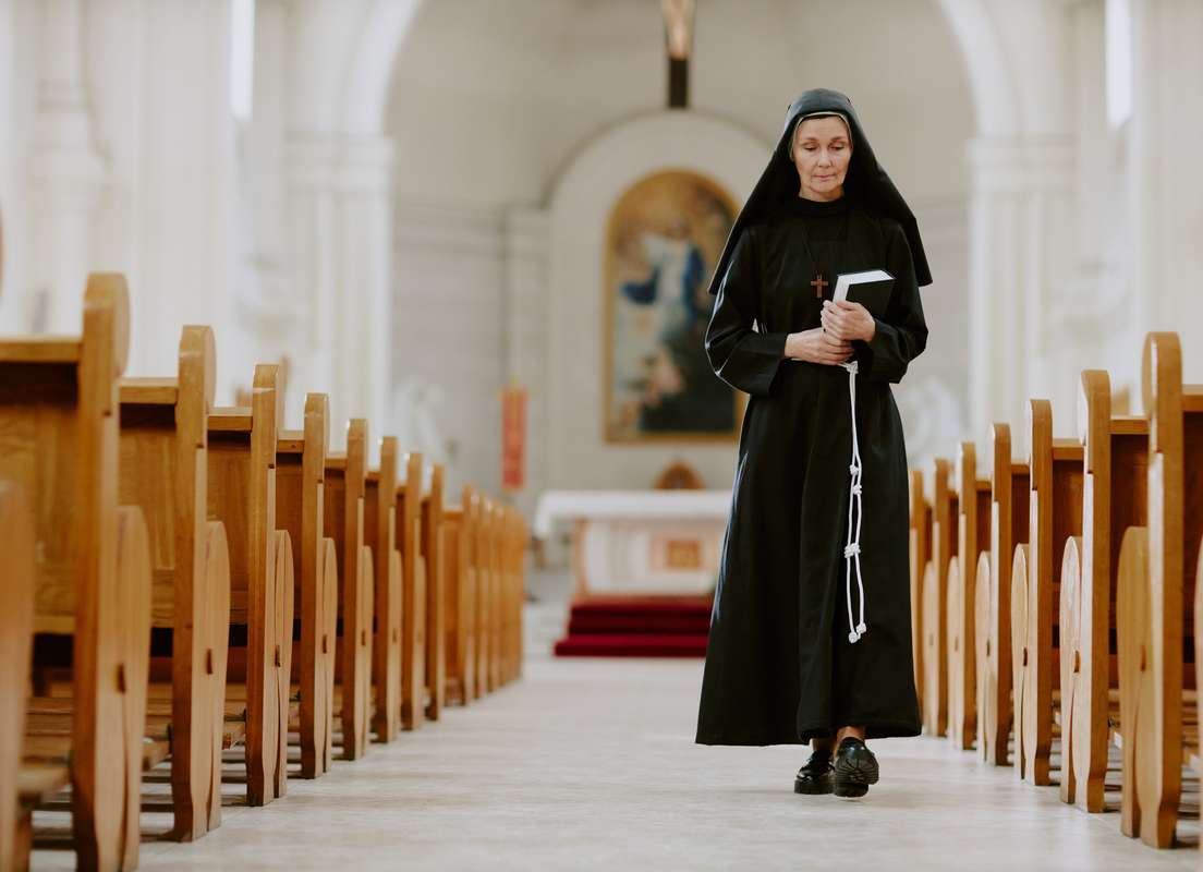 Nun walking in a church