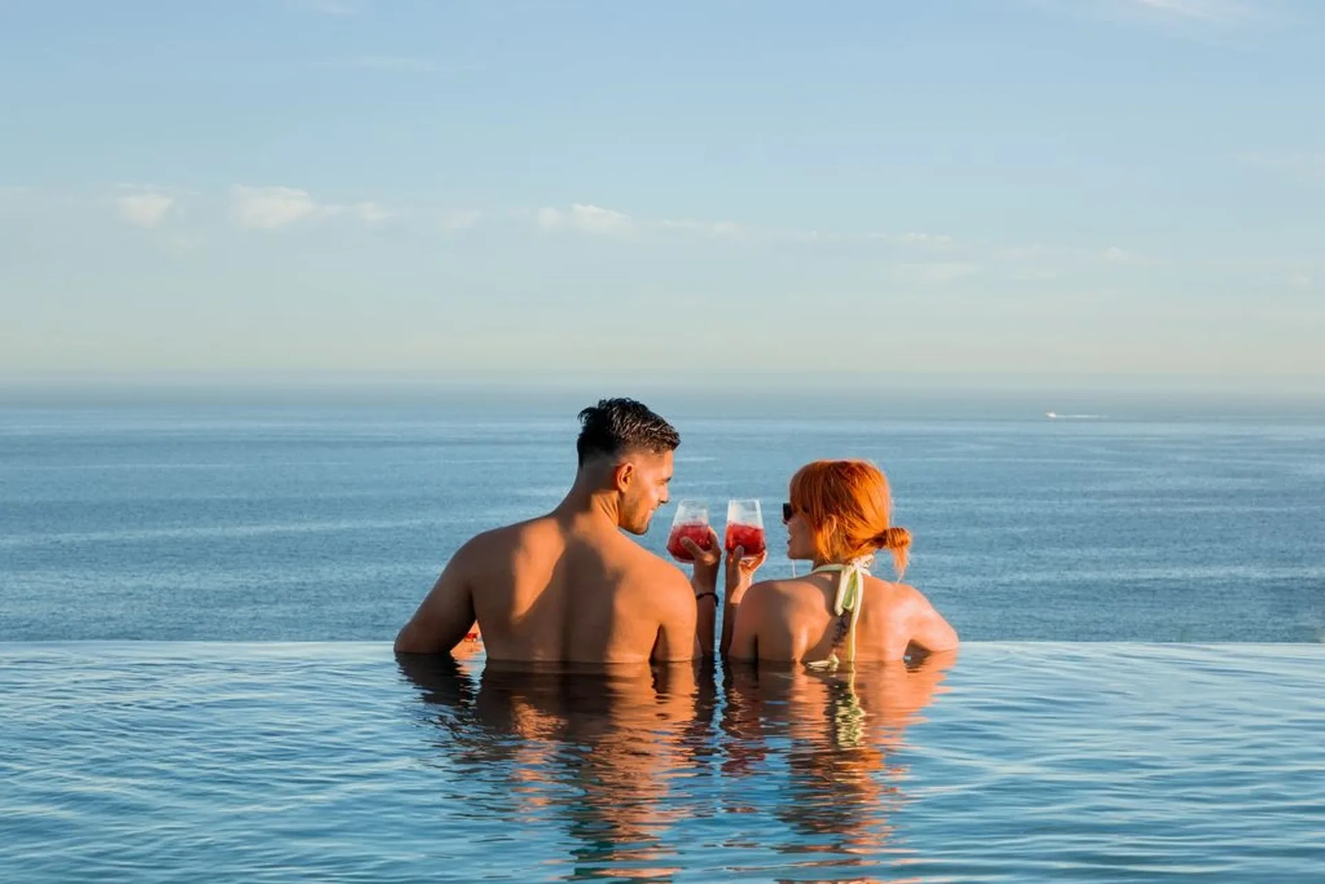 couple in the infinity pool making a toast