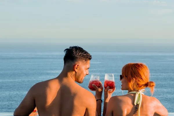 Couple toasting in the rooftop infinity pool with ocean view at Garza Blanca Los Cabos