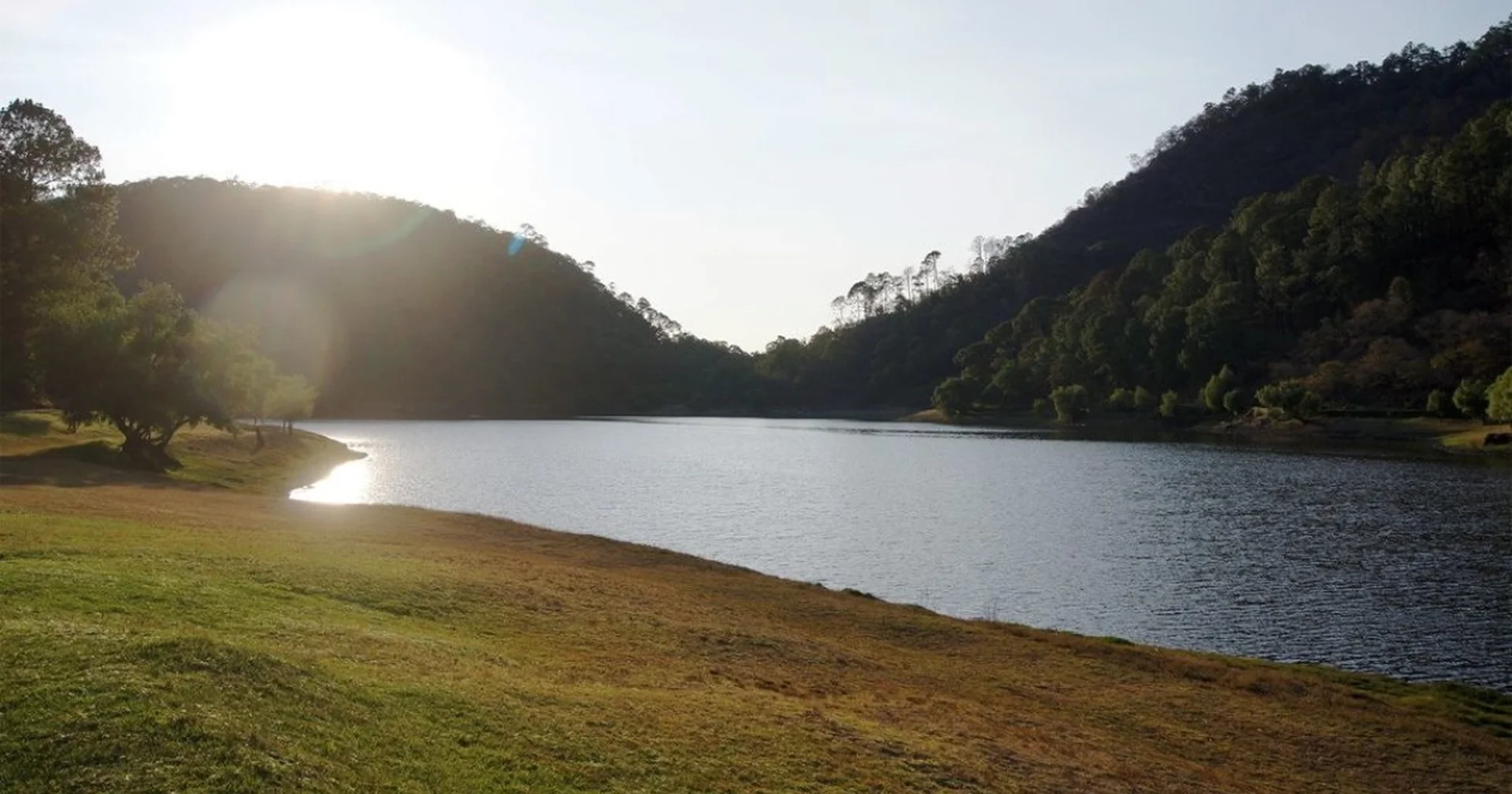 Lake surrounded by forested mountains at sunset in the Jalisco highlands
