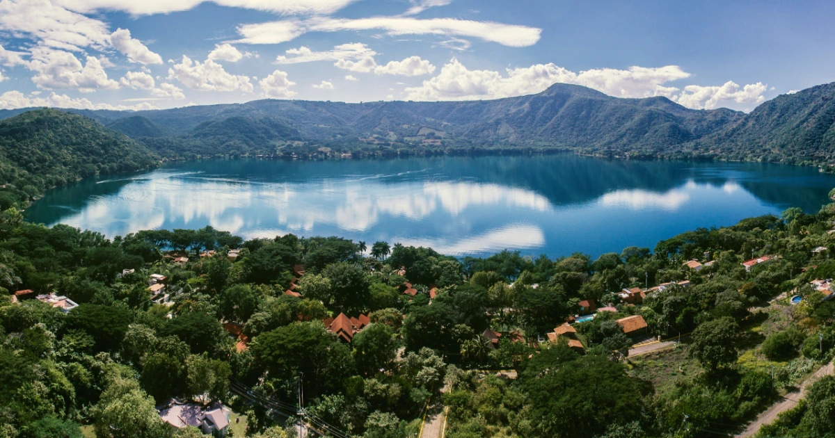 Aerial view of the Santa María del Oro crater lake surrounded by green hills