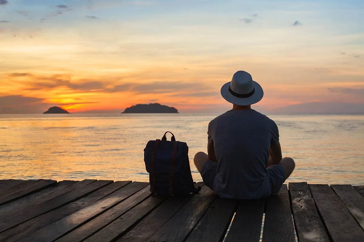 man traveling by himself watching the sunset